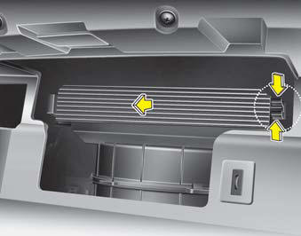 3. Remove the climate control air filter cover while pressing the lock on the